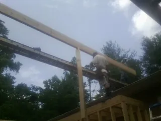 Carpenter setting a ridge beam over a new addition frame — Ice Dam Removal by Roofing Brothers in Pine Island